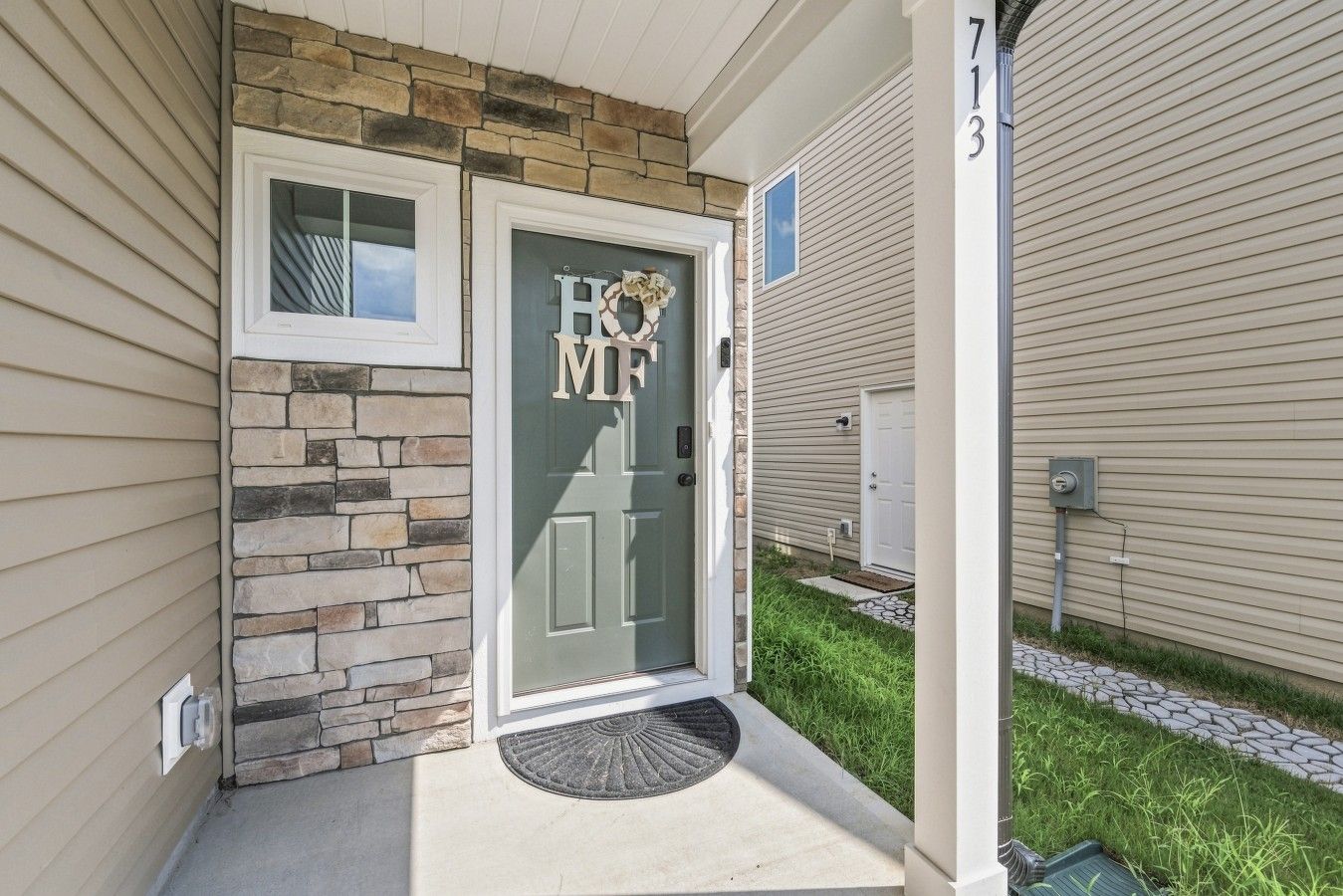 A house with a stone facade, a front door with a wreath, and a mailbox.