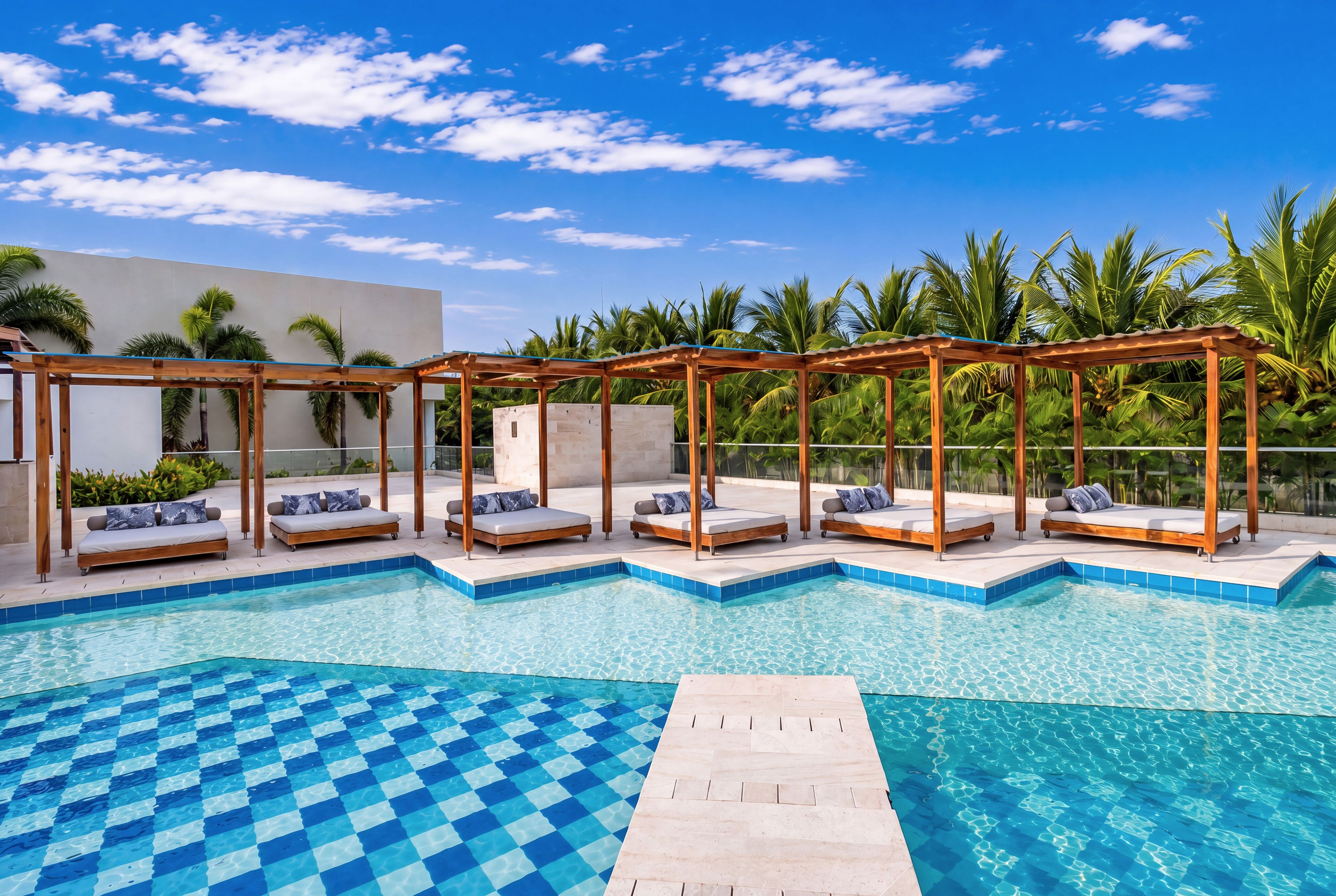 Ein Poolbereich mit mehreren Liegestühlen und einem Schachbrettmuster auf dem Poolboden.
