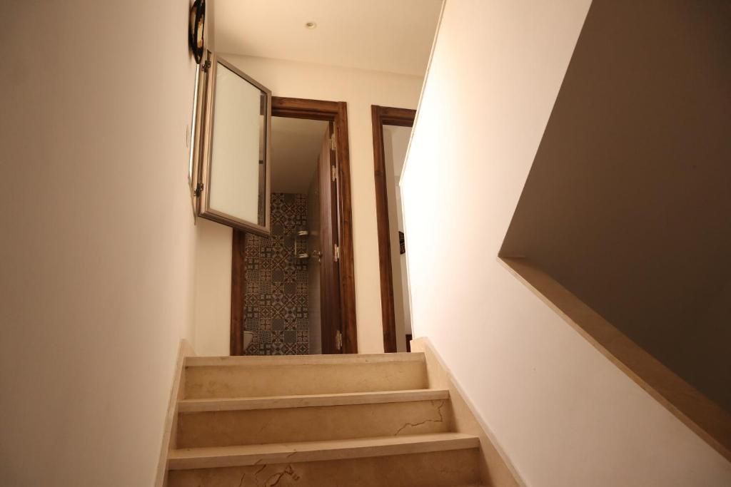 Una escalera conduce a una habitación con piso estampado.