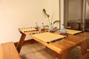 Ein Holztisch mit gewobenen Tischsets und dekorativen Keramikobjekten.