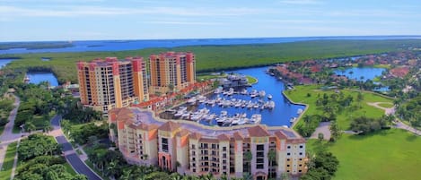 Un resort con varios edificios altos, un puerto deportivo y vegetación circundante.