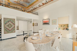 Un'ampia sala da pranzo con soffitto alto e vista sul piano superiore.