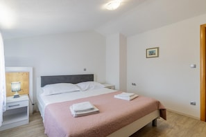 A bedroom with a bed, a bedside table, a lamp, and a picture on the wall. - Hilly Stone Villa for 10 Guests in Donji Vinjani (Donji Vinjani)