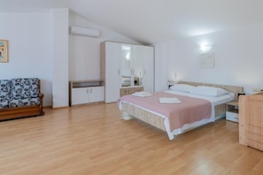 A bedroom with a bed, a wardrobe, a chair, and an air conditioning unit. - Hilly Stone Villa for 10 Guests in Donji Vinjani (Donji Vinjani)