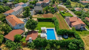 A residential area with multiple houses, a swimming pool, and a well-maintained garden.