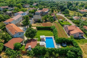 A residential area with multiple houses, a swimming pool, and a well-maintained garden.
