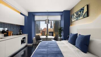A modern hotel room with a large bed, a dining area, and a kitchen.