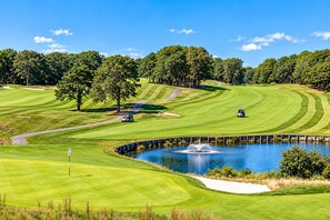 A golf course with a pond, trees, and a clear sky. - A Storybook Cape Cod Cottage by the Sea (Mashpee)