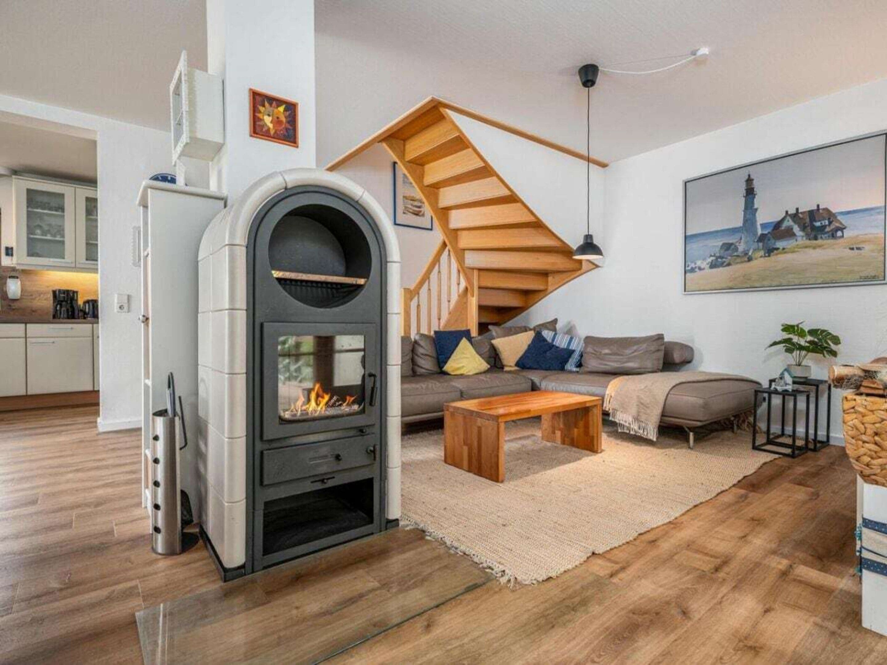 A modern living room with a wood-burning stove, a staircase, a sofa, and a coffee table.
