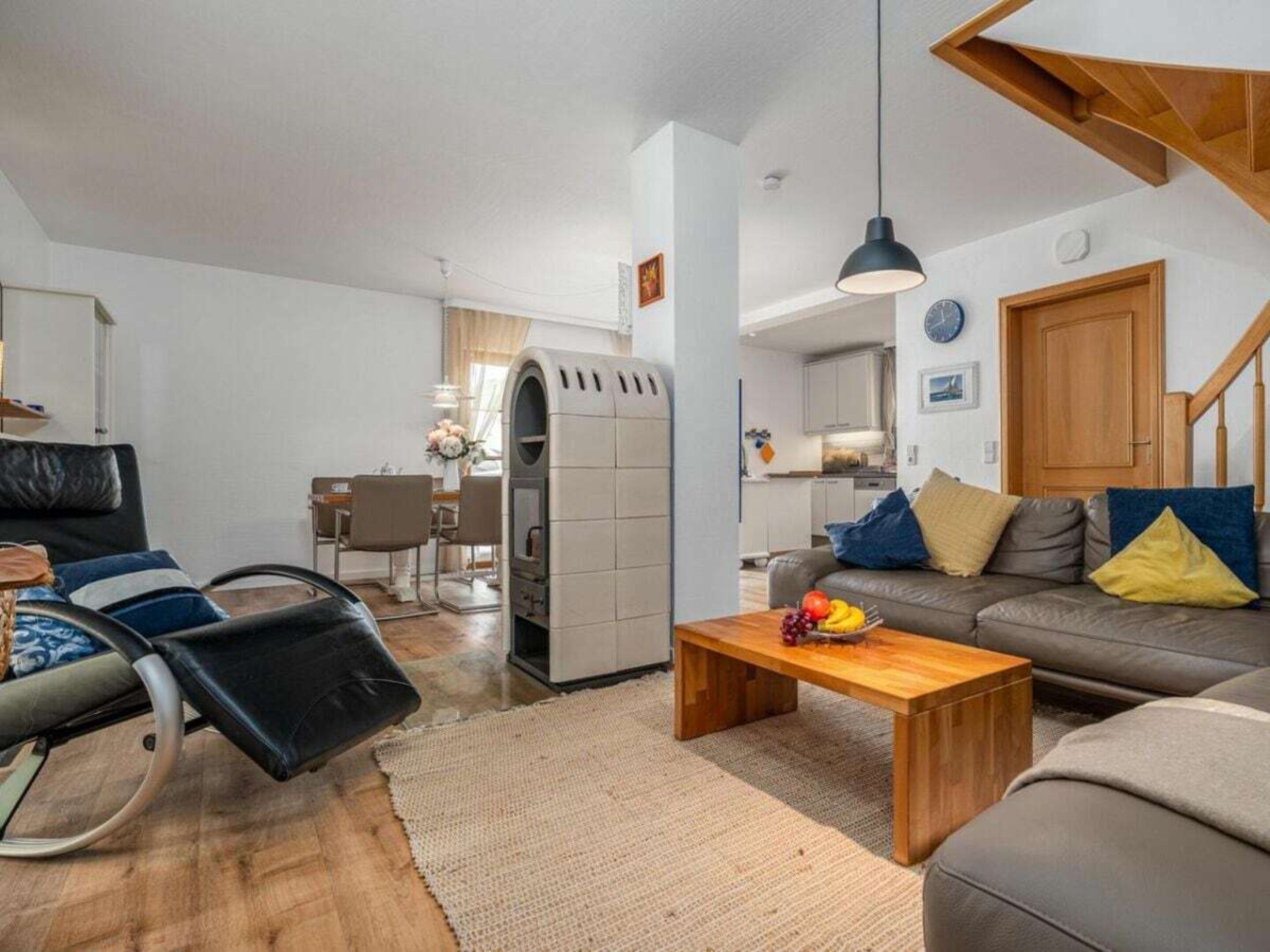 Un salon moderne comprenant un canapé, une table basse et un coin repas avec des chaises et une table.