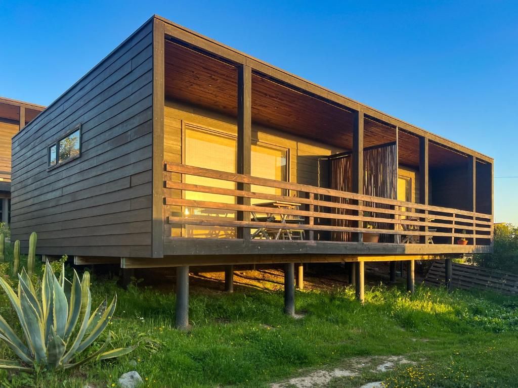 A modern house with a wooden deck and a covered outdoor area.