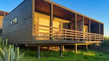 A modern house with a wooden deck and a covered outdoor area.