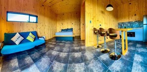 Un interior de madera con un sofá, una cama y un comedor.