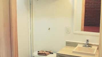 A bathroom with a toilet, sink, and a towel rack.