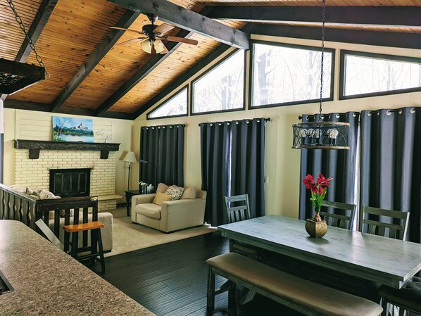 A cozy interior with a fireplace, a dining area, and a seating space.