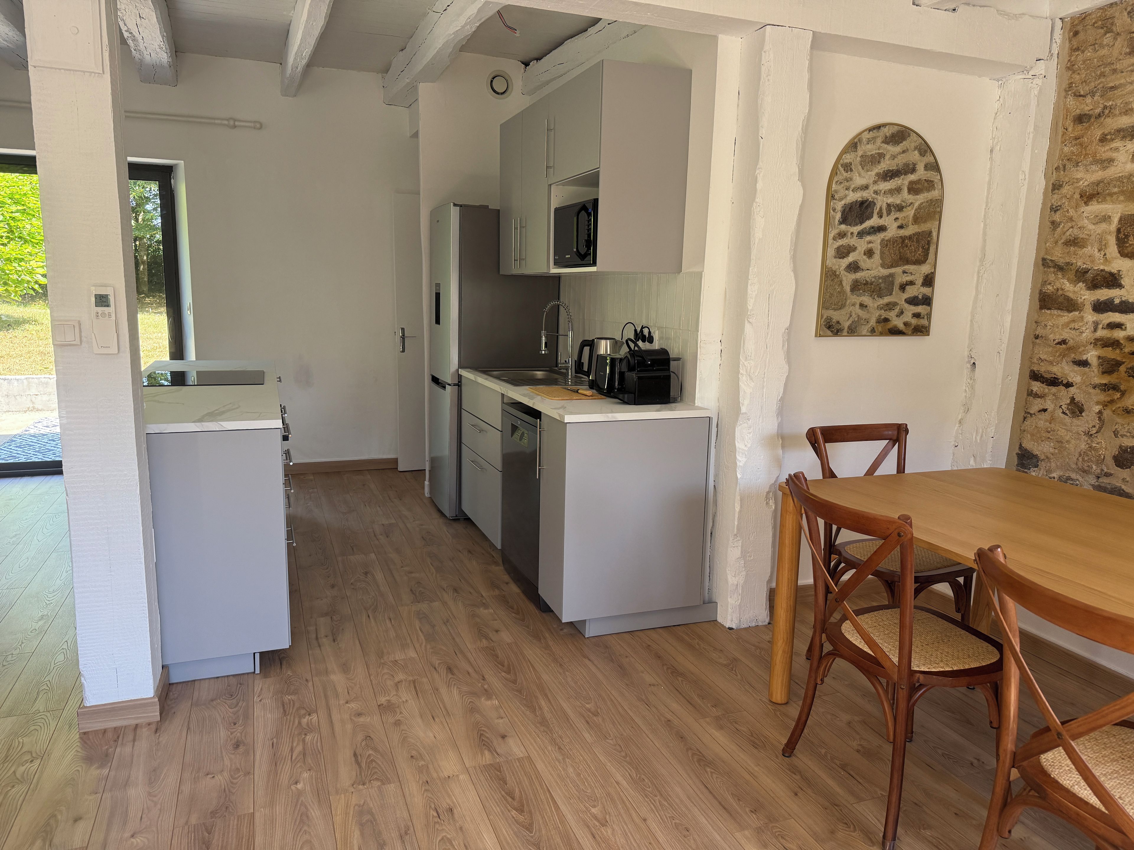 A compact kitchen with white cabinetry, a built-in microwave, and a coffee maker on the countertop.