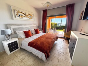 A modern bedroom with a large bed, a desk, and a view of the outdoors. - Beautiful modern Apartment with GYM (Estepona)