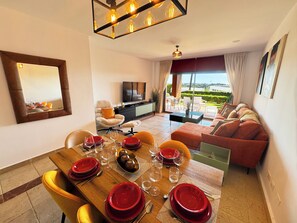 A modern living room with a dining area, a sofa, and a television. - Beautiful modern Apartment with GYM (Estepona)