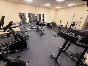 A gym with various exercise equipment, including treadmills, weight machines, and free weights. - Beautiful modern Apartment with GYM (Estepona)