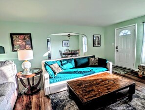 A living room with a sofa, coffee table, and a dining area in the background. - Sunset View Retreat in Central Location (Omaha)