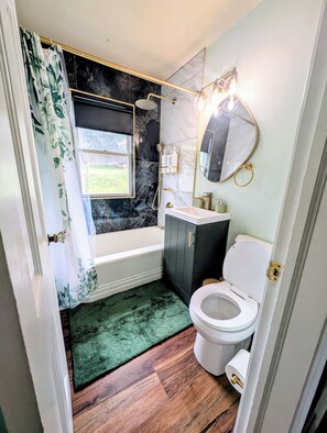 A bathroom with a bathtub, toilet, and shower. - Sunset View Retreat in Central Location (Omaha)