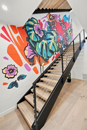 A staircase with a handrail and wooden steps leading to a landing. - The Aperture - Garage - 0.5 mi DT (Bentonville)
