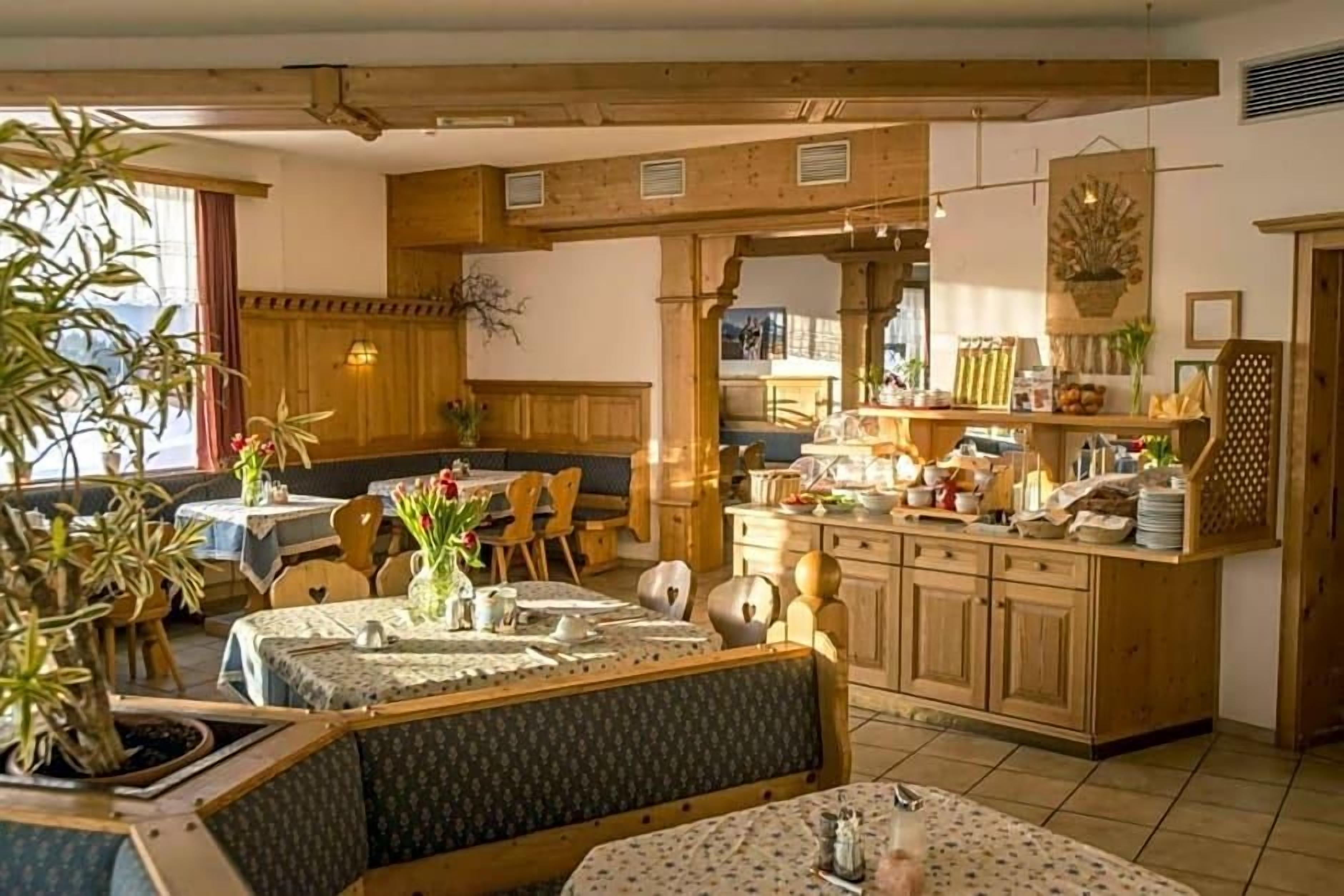 Ein gemütlicher Essbereich mit Holzmöbeln, eine Küchenzeile mit Schränken und ein Tisch für zwei Personen.