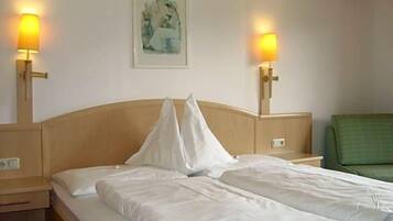 Ein Hotelzimmer mit zwei Betten, Nachttischen, Wandlampen und einem gerahmten Bild an der Wand.