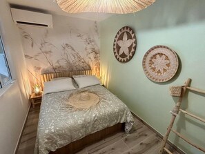 Ein Schlafzimmer mit einem Bett, einer Wand-Klimaanlage und einer Holzleiter.