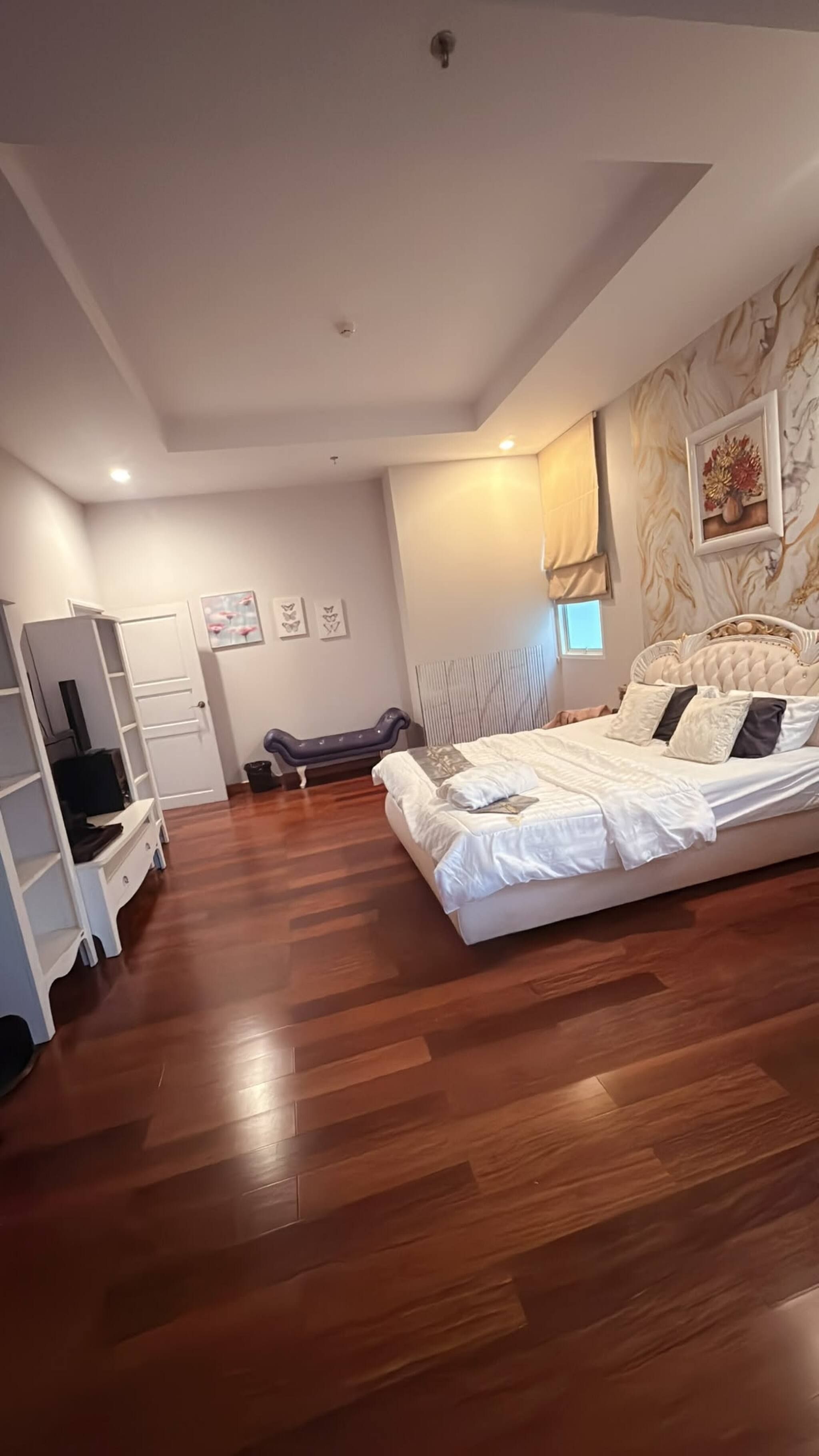 A bedroom with a bed, a wardrobe, a desk, and a chair.