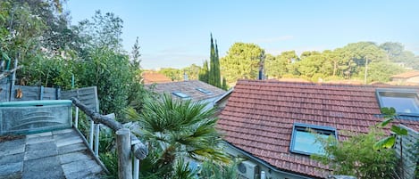 A residential area with a staircase leading to a house with a red-tiled roof.