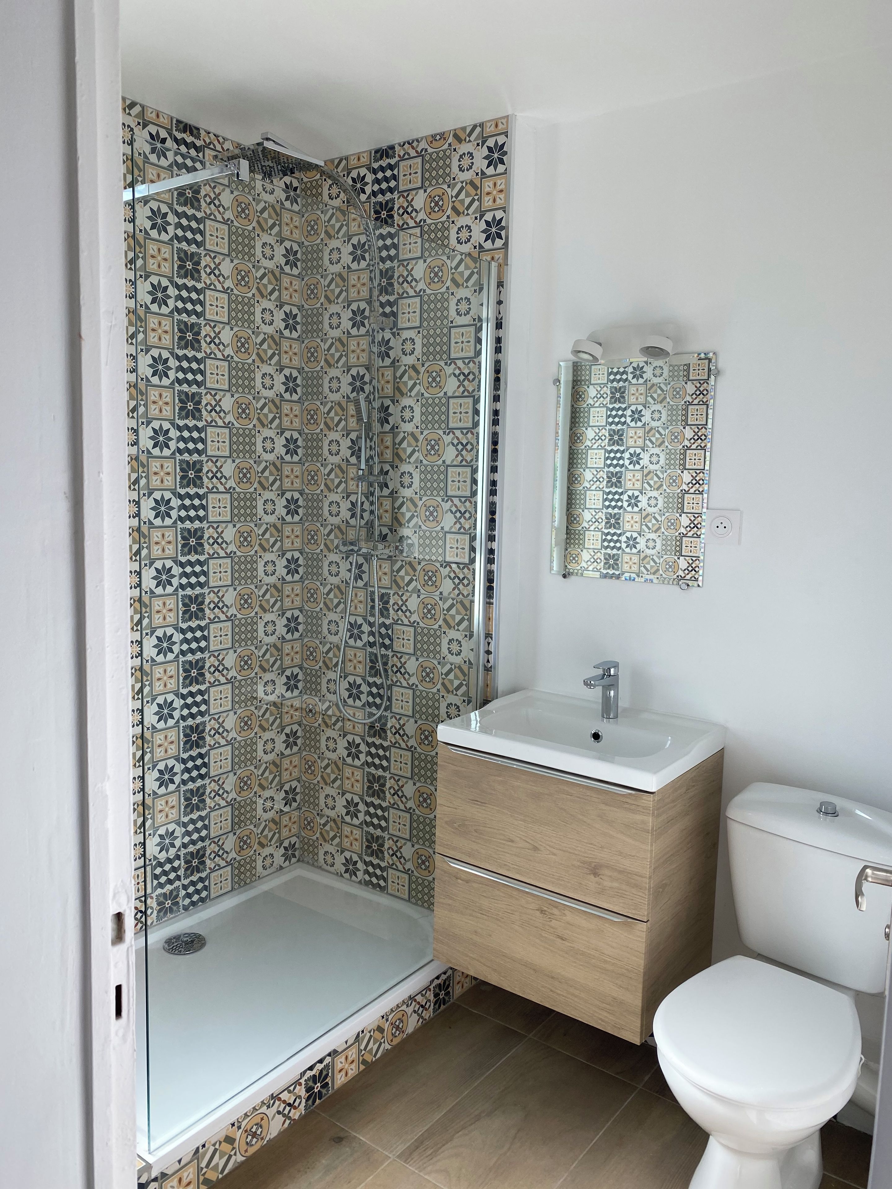 A bathroom with a shower, toilet, and sink.