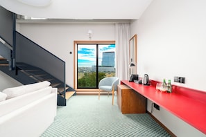 A modern room with a red countertop, a white sofa, a chair, a desk, and a view of a cityscape through a large window. - PERON 12 GWARNA (Wrocław)