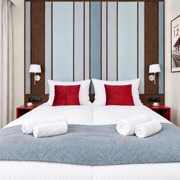 A hotel room with a large bed, two nightstands, a headboard with vertical panels, and a framed picture on the wall. - PERON 12 GWARNA (Wrocław)