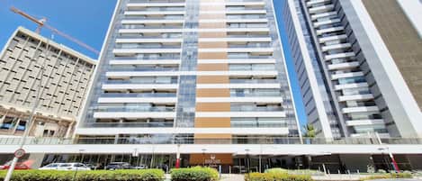 A multi-story hotel with a modern facade, a prominent entrance, and a view of the surrounding urban area.