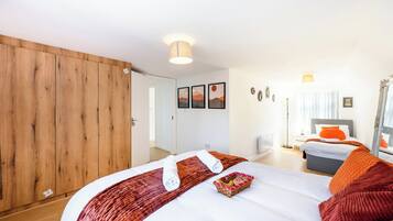 Habitación de hotel con una cama grande, un armario, un escritorio y un espejo.