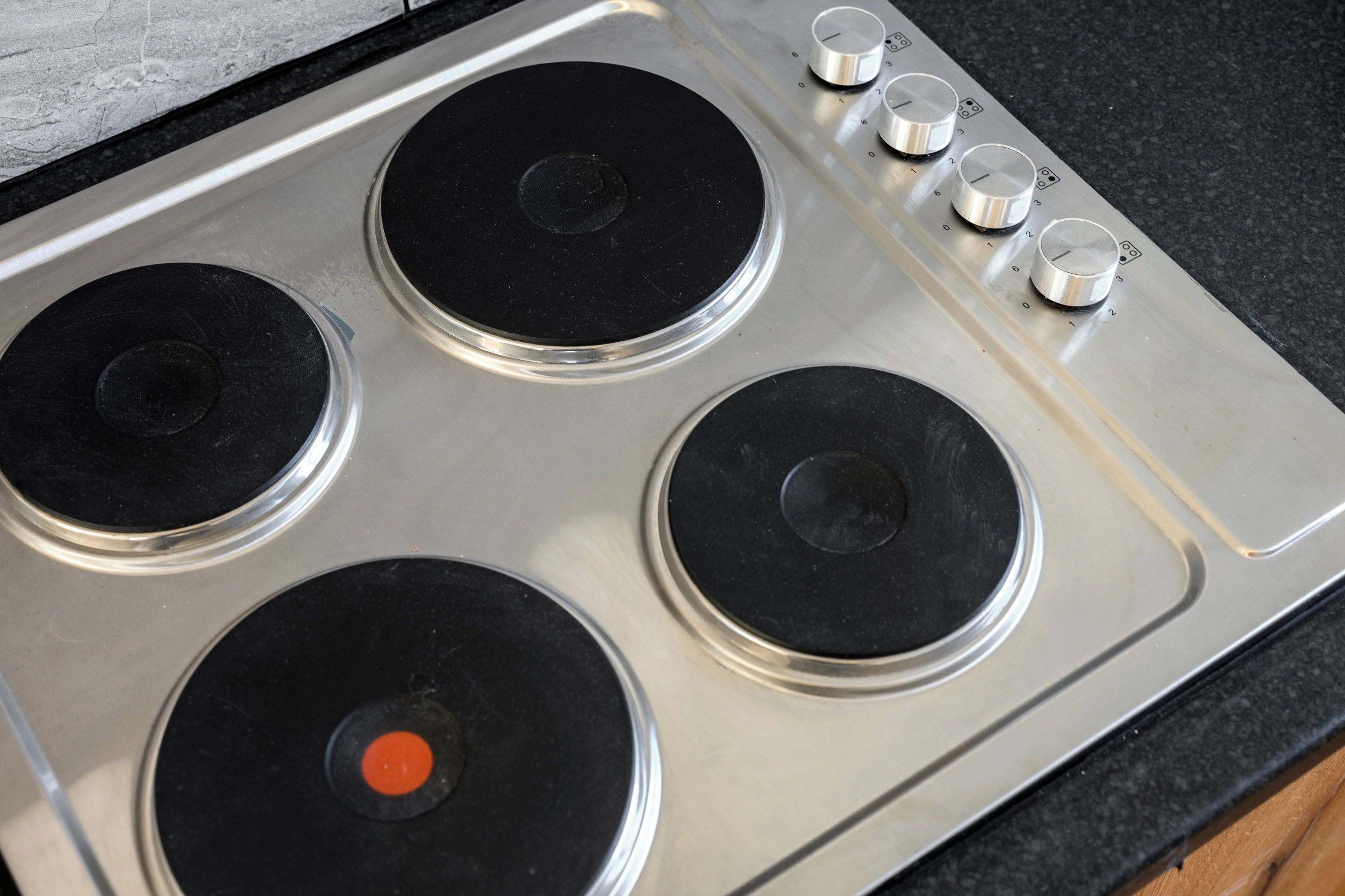 Une plaque de cuisson en acier inoxydable dotée de quatre brûleurs et d’un panneau de commande.