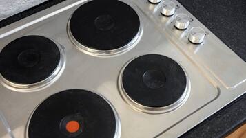 Une plaque de cuisson en acier inoxydable dotée de quatre brûleurs et d’un panneau de commande.