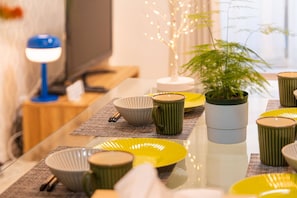 A dining table set with bowls, plates, and a potted plant. - sora nishikujo (Osaka City,Konohana Ward)
