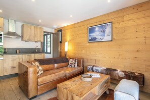 Een modern interieur met een houten wand, een bank, een salontafel en een lijst met een afbeelding.