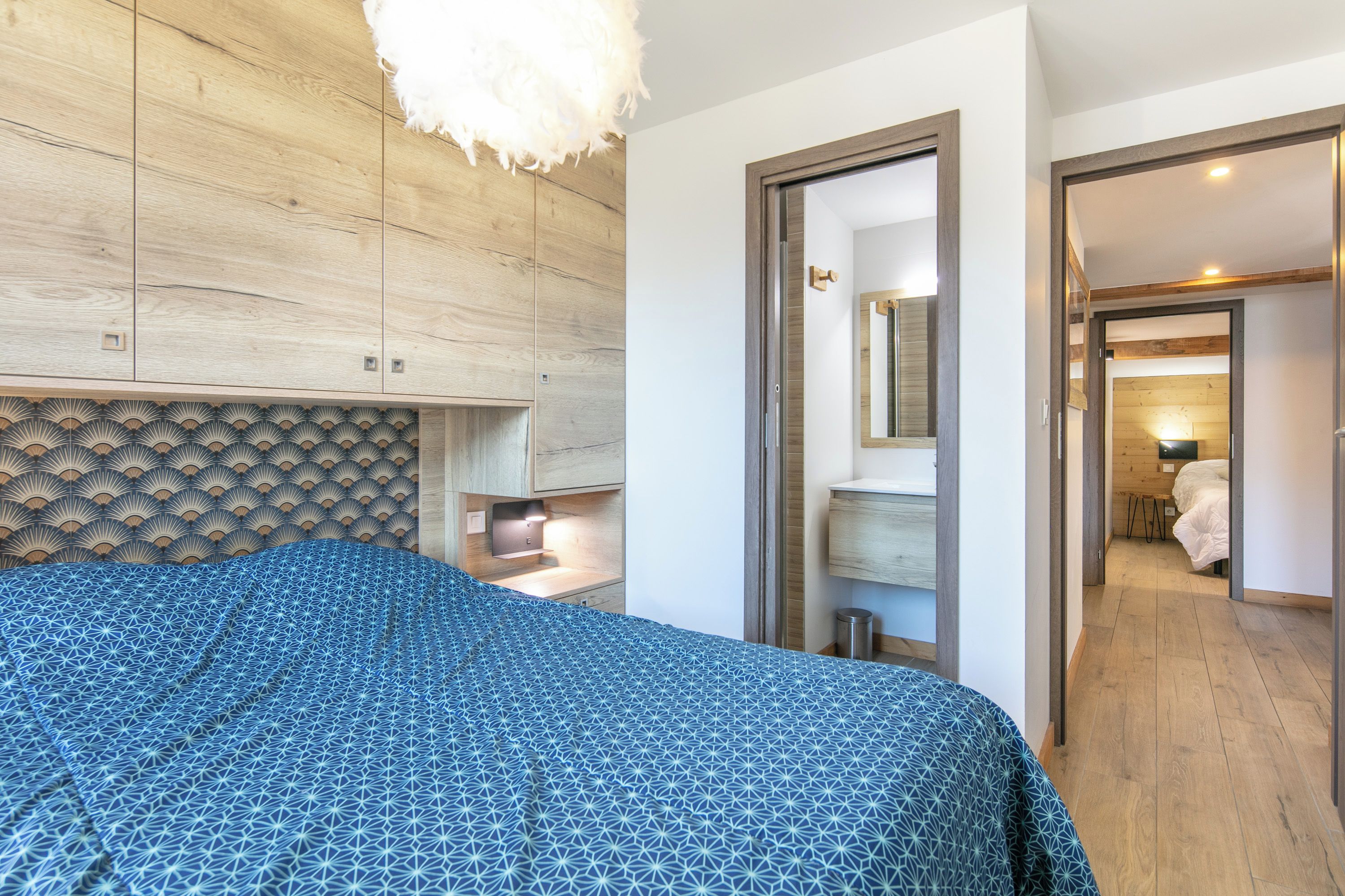 Une chambre à coucher comprenant un lit, une table de chevet, un miroir et une armoire.