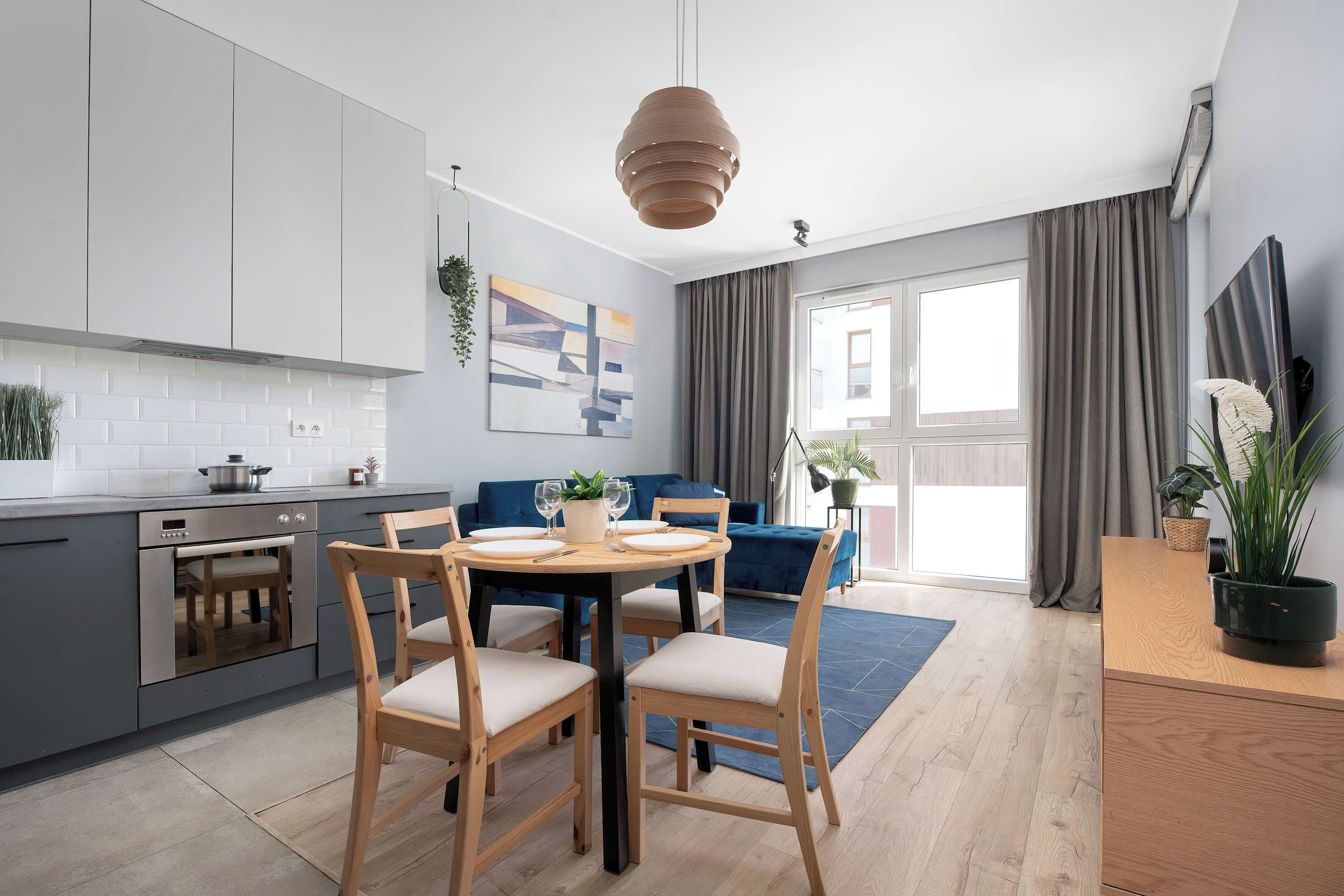 Une cuisine moderne avec un coin repas, une grande fenêtre et une vue sur l’extérieur.
