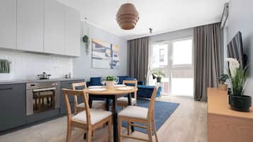 Une cuisine moderne avec un coin repas, une grande fenêtre et une vue sur l’extérieur.