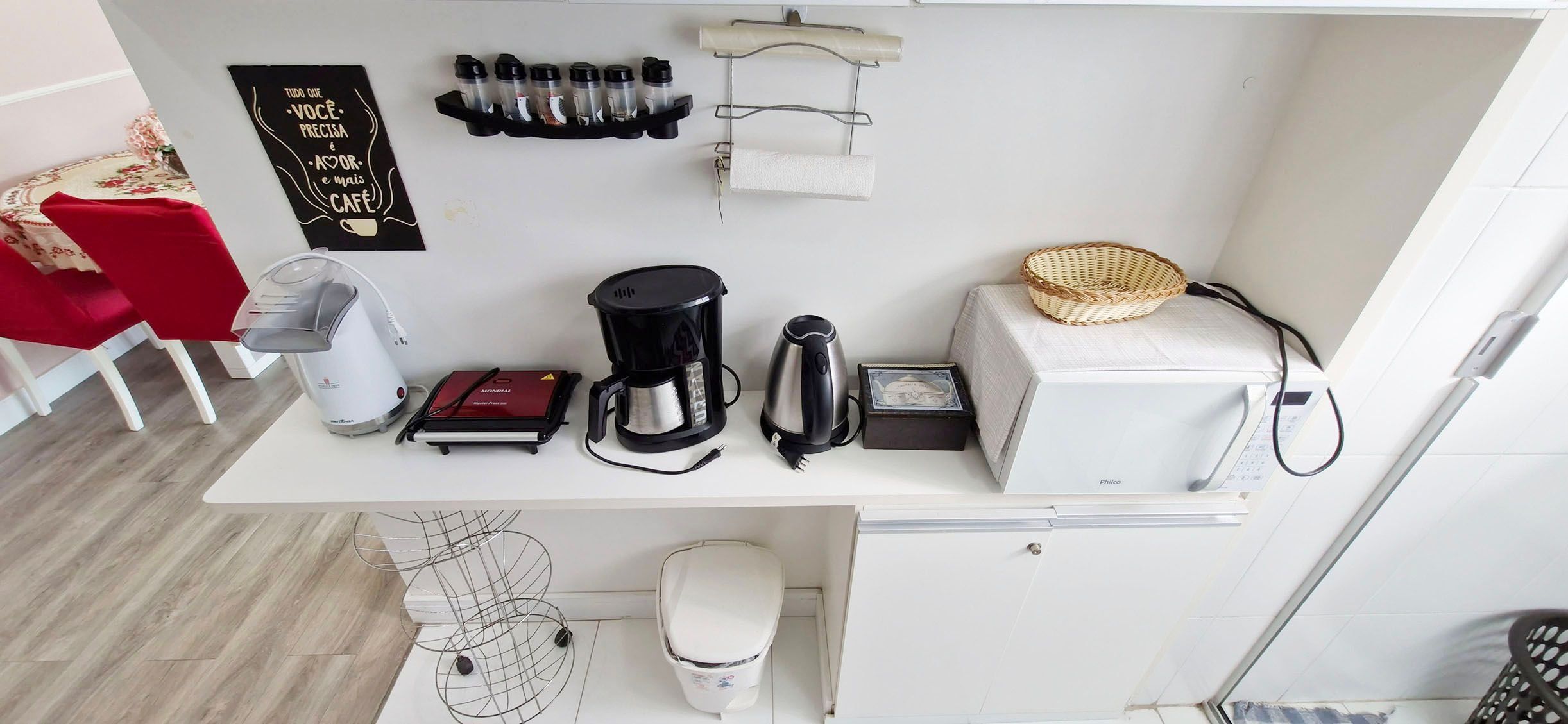 A compact kitchenette with a coffee maker, kettle, toaster, and a small refrigerator.