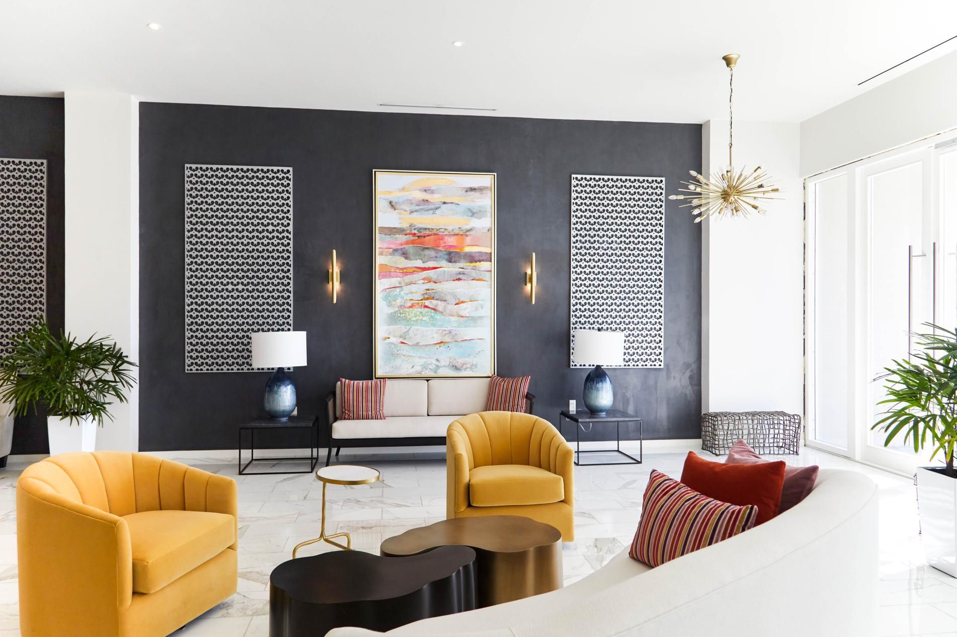 A modern living room with a sofa, armchairs, a coffee table, and a large abstract painting.