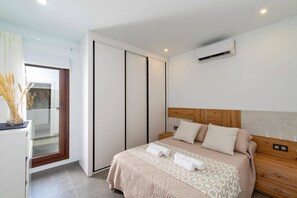 Une chambre moderne équipée d’un lit, d’une armoire et d’un appareil de climatisation.