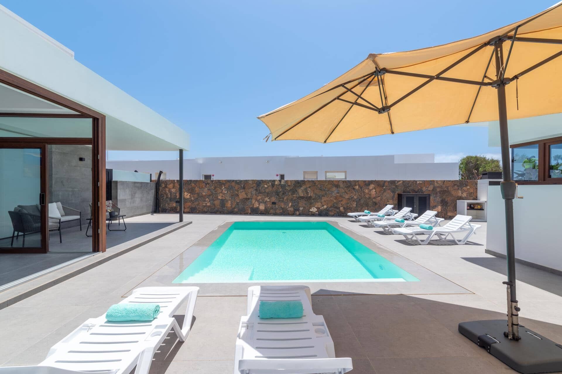 A swimming pool with lounge chairs and a canopy.