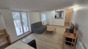 En moderne stue med en sofa, et lille bord og et fjernsyn.