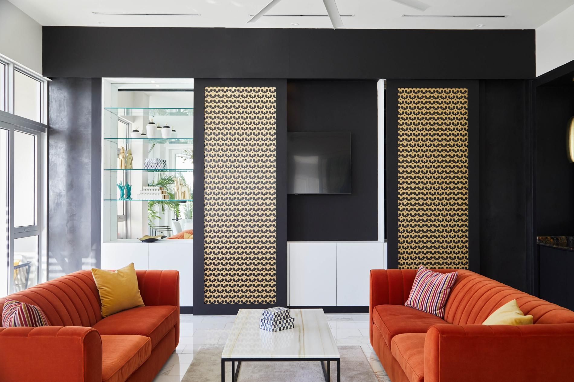 Un salon moderne avec deux canapés, une table basse et un téléviseur fixé au mur.
