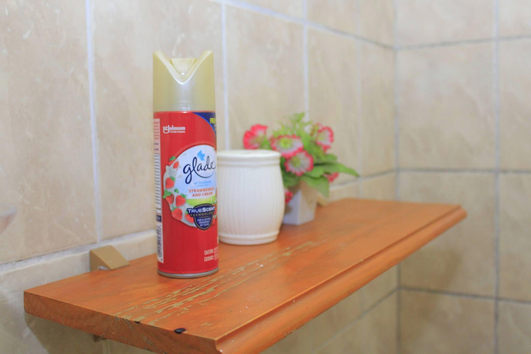 A can of Johnson's Glade strawberry and cream on a wooden shelf.